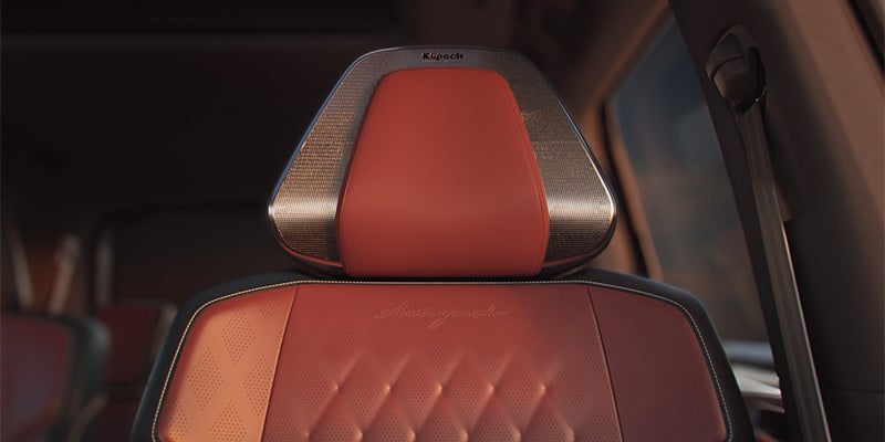 Close-up of a car seat with brown leather upholstery.